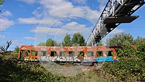 An old pedestrian bridge over the railway and an old rusty broken wagon