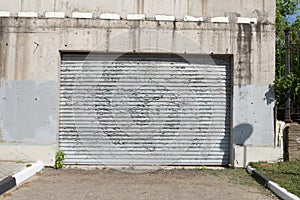 An old, peeling sheet of iron. Fence or garage door. The influence of atmospheric precipitation on the paintwork