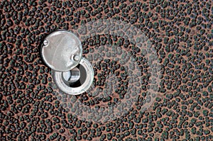 Old peephole on the metal door