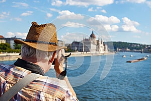 Old pensioner tourist shooting Parliament building at Budapest