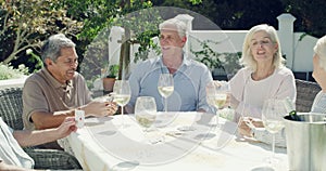 Old people, friends and play cards outdoor or drink wine in backyard garden or entertainment, competition or party. Man