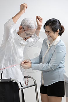 Old people measuring waist with tape measure,smiling asian senior woman raise hands feels happy satisfaction,proud of her weight