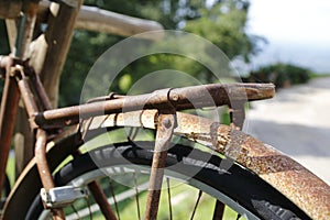 Old person, rusty bicycle , hangs on a wooden beam