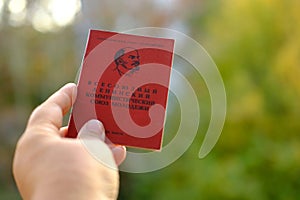 old personal document in female hand, red Komsomol card, political youth organization, citizen of USSR middle of twentieth century