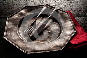 Old pewter plate with eating utensils photo