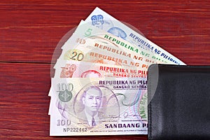 Old Philippine peso in the black wallet