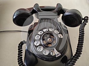 Old phone hanging on the wall. Black color. Vintage photo