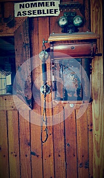 Old phone mounted to a wooden wall