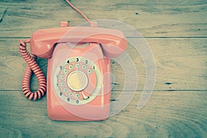 Old phone rotary vintage retro stlye telephone on wood table top