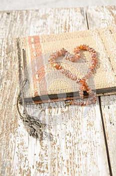 Old photo album with amber necklace heart