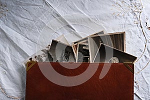 Old photo albums lie on white mint tablecloth, vintage photographs, concept of family tree, genealogy, childhood memories,