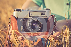 Old photo camera in a hands of girls.