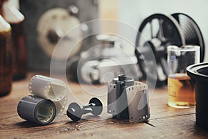 Old photo film rolls, cassette and photographic equipment on background - developing tank with its film reels, retro camera, timer