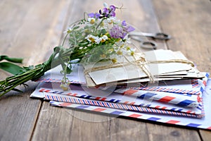 Old photographs, envelopes from letters, wild flowers bouquet on table, home archive documents, concept of family tree, genealogy