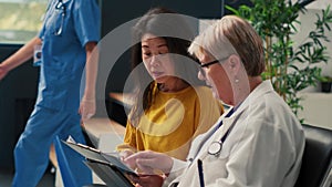 Old physician and asian woman doing checkup examination