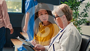 Old physician and asian woman doing checkup examination