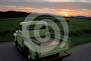 An old pickup truck drives along a rural road