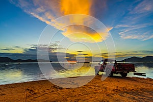 Old pickup truck parked on the waterfront with sunset at Bang phra reservoir ,sriracha chon buri,  thailand