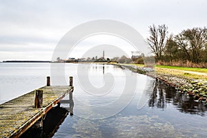 Old pier on the Lake Veere surrounded by greenery under the cloudy sky in the Netherlands