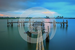 An old pier near the beach with beautiful panorama at sunset