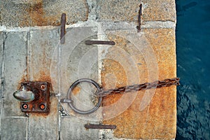 Old pier with a rusty chain and ring