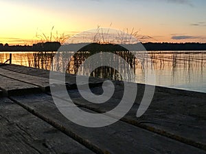 Old pier, sunset in the river