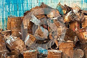 Old pile of rusty paint cans against wall