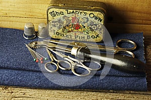 OLD PIN BOX WITH THIMBLES, SCISSORS, GLASSHEAD PINS AND TRACING WHEEL
