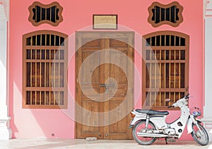 Old pink buildings Sino-Portuguese style with motorcycle in