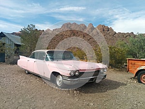 Old, pink Cadillac car in the desert