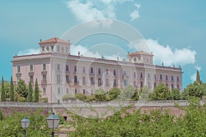 Old pink European palace, surrounded by green gardens