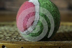 Old pink and green tennis ball on vintage racket