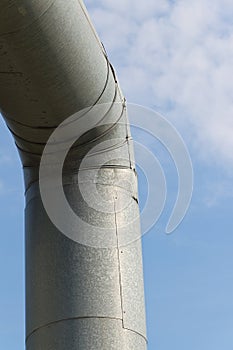 The old pipe on a background of blue sky with white clouds