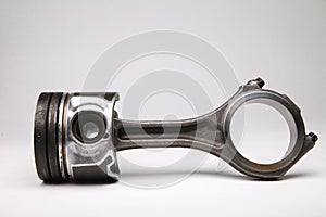 Old piston with a connecting rod on a white background