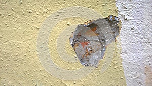 Old plastered brick wall with hole and damage. Plaster exfoliation. Yellow concrete grunge texture. Background. Crisis concept. Co