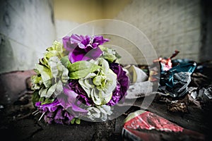 Old plastic flowers on a floor in an abandoned house room.