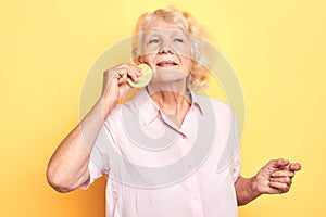 Old pleasant attractive woman using sponge while taking care of her face