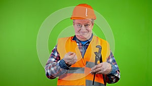 Old plumber with adjustable wrench boast his lucrative job and doing thumbs up.