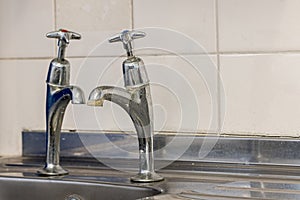 Old plumbing. Badly fitted sink taps with limescale. Selective f photo