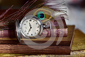 Old pocket watch and books on a table. Vintage still