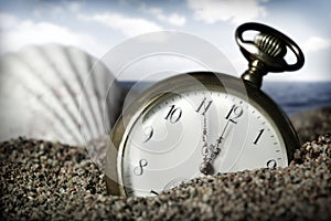 Old pocket watch buried in sand