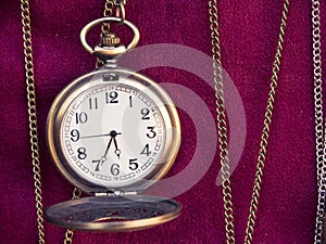 Old pocket watch and chains on the red floor