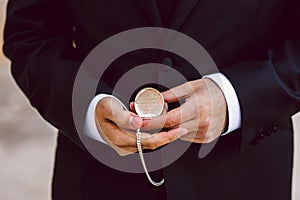 Old pocket watch in the hands of a man