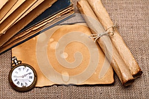 Old pocket watch with rolls and books