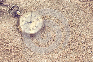 Old pocket watch in the sand