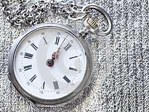 old pocket watch on silver cloth close up