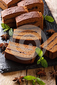 Old Polish ginger cake piernik with plum jam close-up. vertical