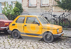 Classic Polish small car Polski Fiat 126p yellow compact parked