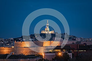 The Old Port and Basilica of Notre Dame de la Garde at dusk in Marseille, France