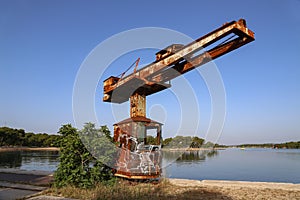 Old port crane rusts in the sun photo